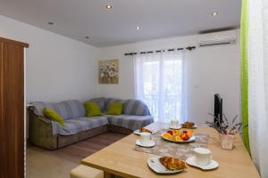 ein Wohnzimmer mit einem Sofa und einem Tisch in der Unterkunft Apartments with a parking space Marina, Trogir - 14258 in Marina