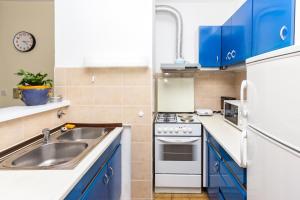 a kitchen with blue cabinets and a sink at Apartments with a parking space Omis - 14290 in Omiš