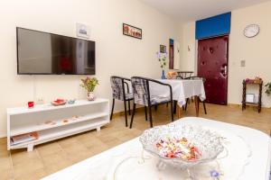 a living room with a table and a tv on the wall at Apartments with a parking space Omis - 14290 in Omiš