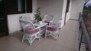 Apartments with a parking space Tugare, Omis - 14320 في Tugare: طاولة بيضاء وكراسي على شرفة مع نبات