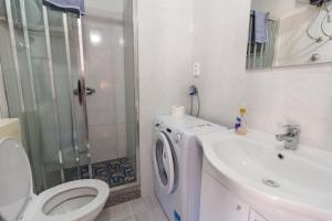 a bathroom with a toilet a sink and a washing machine at Apartments by the sea Petrcane, Zadar - 14327 in Petrcane