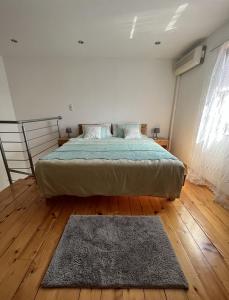 a bedroom with a bed and a rug on a wooden floor at Apartments by the sea Martinscica, Cres - 14334 in Martinšćica