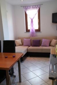 a living room with a couch and a window at Apartments by the sea Martinscica, Cres - 14334 in Martinšćica