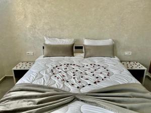 a large white bed with hearts on it at Moussa Residence in Dakhla