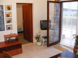 ein Wohnzimmer mit einem TV und einem Spiegel in der Unterkunft Apartments by the sea Sevid, Trogir - 14337 in Marina