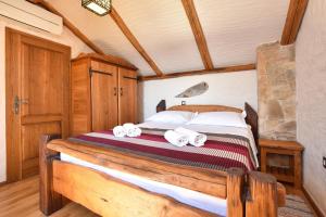 1 dormitorio con 1 cama con toallas en Secluded fisherman's cottage Cove Golubinka, Hvar - 14344, en Zastražišće