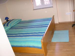 un letto con una coperta a righe blu e blu sopra di Apartments with a parking space Opric, Opatija - 14349 a Lovran (Laurana)