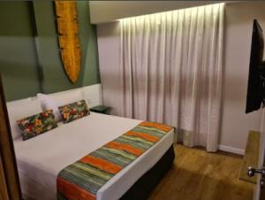 una camera da letto con un letto grande con una finestra di Hot Beach Suites Olímpia a Olímpia Altre 25 foto