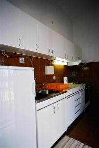 una cocina con fregadero y refrigerador en Seaside holiday house Ist - 14366, en Ist