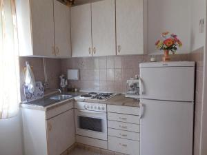 a kitchen with white appliances and a white refrigerator at Apartments by the sea Povlja, Brac - 14367 in Povlja