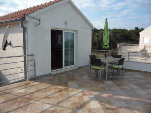 a patio with a table and chairs and a umbrella at Apartments with a parking space Savar, Dugi otok - 14373 in Savar