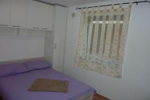 a bedroom with a purple bed and a window at Apartments with a parking space Vir - 14389 in Vir