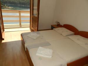 two twin beds in a room with a balcony at Apartments by the sea Povlja, Brac - 14399 in Povlja