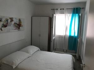 a bedroom with a white bed and a window at Apartments by the sea Stupin Celine, Rogoznica - 14416 in Podglavica