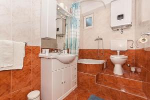 a bathroom with a sink and a toilet and a shower at Apartments with parking space Omis - 14422 in Omiš