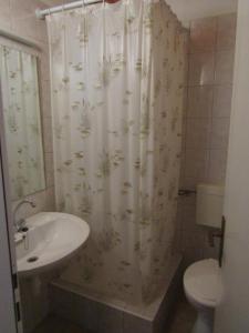 La salle de bains est pourvue d'un lavabo et d'un rideau de douche. dans l'établissement Apartments by the sea Tisno, Murter - 14410, à Tisno