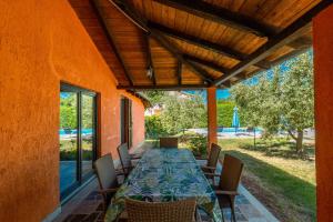 une terrasse avec une grande table et des chaises. dans l'établissement Family friendly house with a swimming pool Sveti Lovrec, Central Istria - Sredisnja Istra - 14432, à Sveti Lovreč Pazenatički