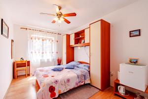 1 dormitorio con 1 cama y ventilador de techo en Apartments and rooms with parking space Mali Ston (Peljesac) - 14434, en Mali Ston