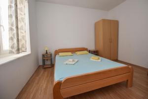 a small bedroom with a bed and a cabinet at Holiday house with a parking space Kustici, Pag - 14438 in Zubovići