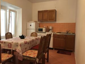 a kitchen with a table with chairs and a microwave at Holiday house with a parking space Kustici, Pag - 14438 in Zubovići