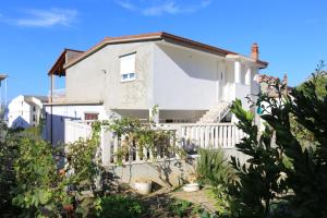 una casa blanca con una valla blanca en Apartments by the sea Sumpetar, Omis - 14450 en Jesenice