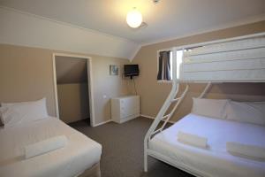 een slaapkamer met 2 bedden en een stapelbed bij Blizzard Bunny Lodge 43 Gippsland Street in Jindabyne