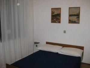 a bedroom with a bed and two pictures on the wall at Apartment Krk 14484b in Krk