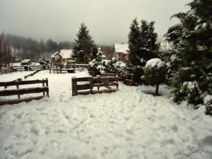 a snow covered yard with benches and trees at Apartments with a parking space Lokve, Gorski kotar - 14469 in Lokve