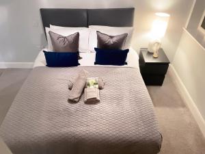 a large bed with two pairs of socks on it at Super Luxe Central Maidenhead Apartment in Maidenhead