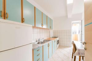 uma cozinha com armários brancos e um lavatório em Apartments with a parking space Privlaka, Zadar - 14492 em Privlaka