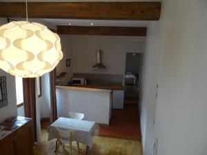 a kitchen and dining room with a table and a chandelier at Wheel River in L'Isle-sur-la-Sorgue