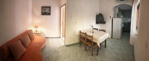 ein Wohnzimmer mit Tisch und Küche in der Unterkunft Apartment Povlja 14399c in Povlja