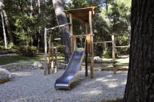 a playground with a slide next to a tree at Apartments by the sea Rab - 14504 in Rab