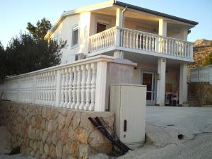 a white house with a wall and a refrigerator at Apartments with a parking space Starigrad, Paklenica - 14507 in Starigrad-Paklenica