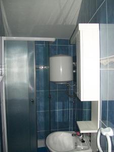 a blue tiled bathroom with a sink and a shower at Apartments with a parking space Starigrad, Paklenica - 14507 in Starigrad-Paklenica