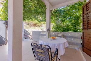 a white table with chairs on a patio at Apartments by the sea Cove Vela Stiniva, Hvar - 14511 in Zastražišće