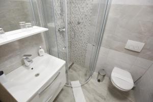 a bathroom with a shower and a toilet and a sink at Apartments and rooms with WiFi Zadar - 14528 in Zadar