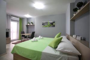 a bedroom with a bed with a green blanket on it at Apartments and rooms with WiFi Zadar - 14528 in Zadar