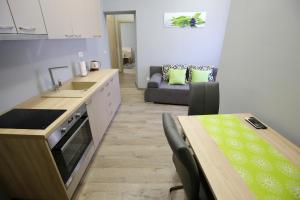 uma cozinha com uma mesa e um sofá num quarto em Apartments and rooms with WiFi Zadar - 14528 em Zadar