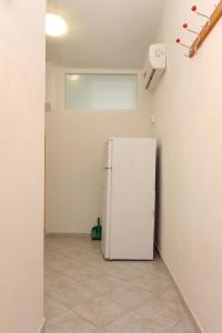 a white refrigerator in a room with a tile floor at Apartments by the sea Slatine, Ciovo - 14541 in Slatine