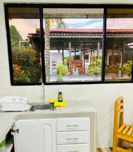 a kitchen with a sink and a view of a house at Hermoso apartamento en condominio privado in Iquitos