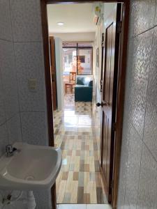 a bathroom with a sink and a room with a couch at Hermoso apartamento en condominio privado in Iquitos