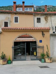 an entrance to a building with a gate at Triple Room Plomin Luka 15078c in Plomin