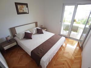 a bedroom with a large bed and a large window at Apartments by the sea Marina, Trogir - 14191 in Marina