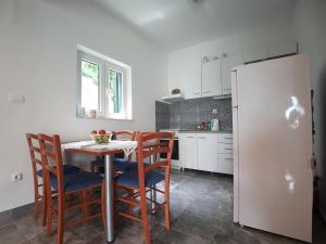 a kitchen with a table and chairs and a refrigerator at Apartments by the sea Marina, Trogir - 14191 in Marina