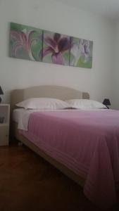sypialnia z fioletowym łóżkiem z obrazem na ścianie w obiekcie Apartments with a parking space Poljica, Trogir - 16299 w Marinie