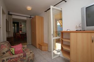 ein Wohnzimmer mit einem TV und einem Sofa in der Unterkunft Apartments with WiFi Rabac, Labin - 16312 in Rabac