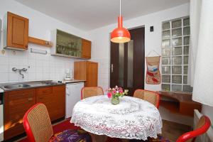 eine Küche mit einem Tisch und einer Blumenvase darauf in der Unterkunft Apartments with WiFi Rabac, Labin - 16312 in Rabac + 7 Fotos