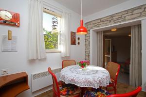 ein Tisch mit Stühlen und einer Vase mit Blumen darauf in der Unterkunft Apartments with WiFi Rabac, Labin - 16312 in Rabac