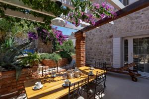 a patio with a table and chairs and flowers at Seaside house with a swimming pool Sutivan, Brac - 16300 in Sutivan